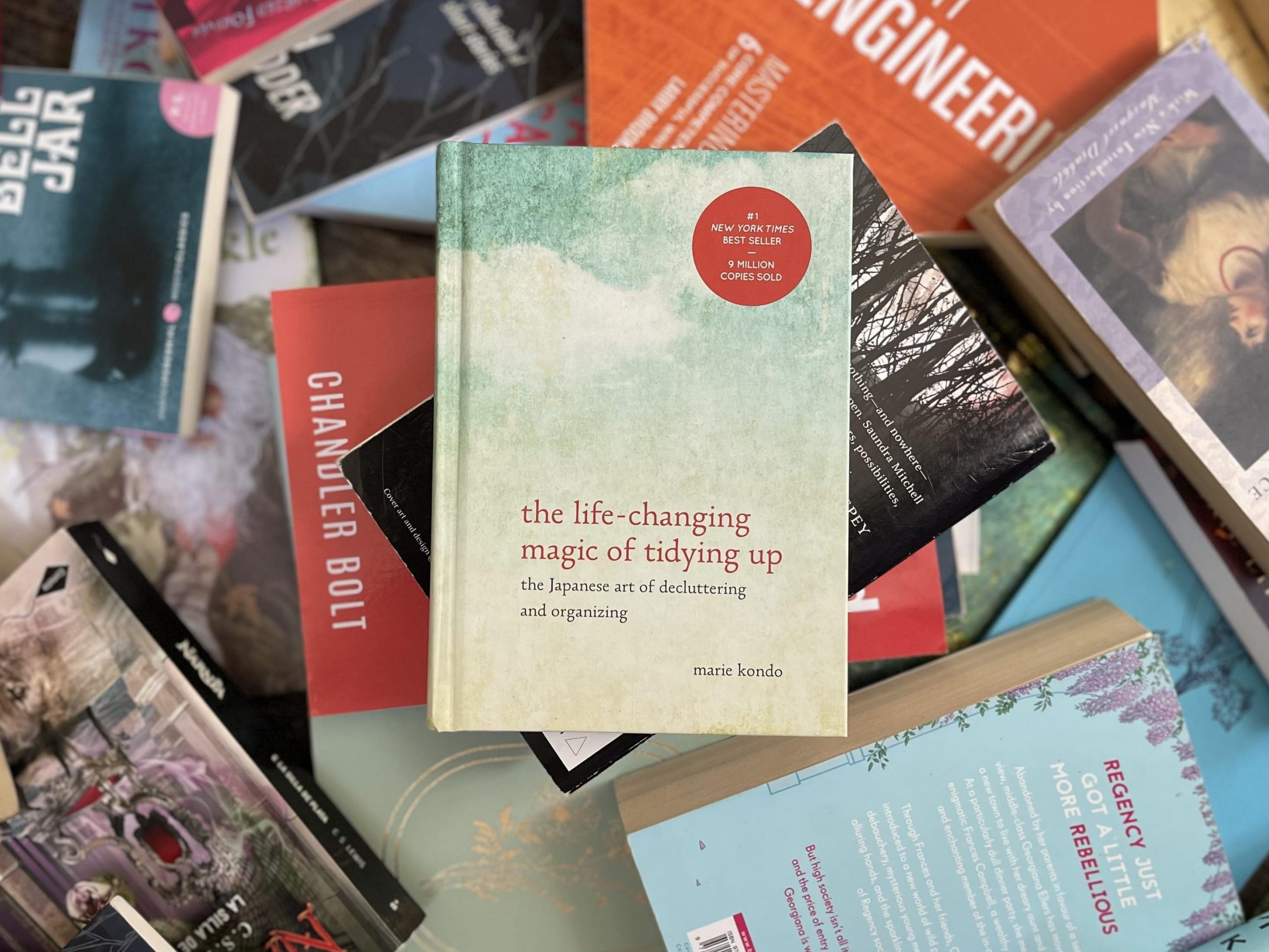 Marie Kondo's the life-changing magic of tidying up on a backdrop of messy books.